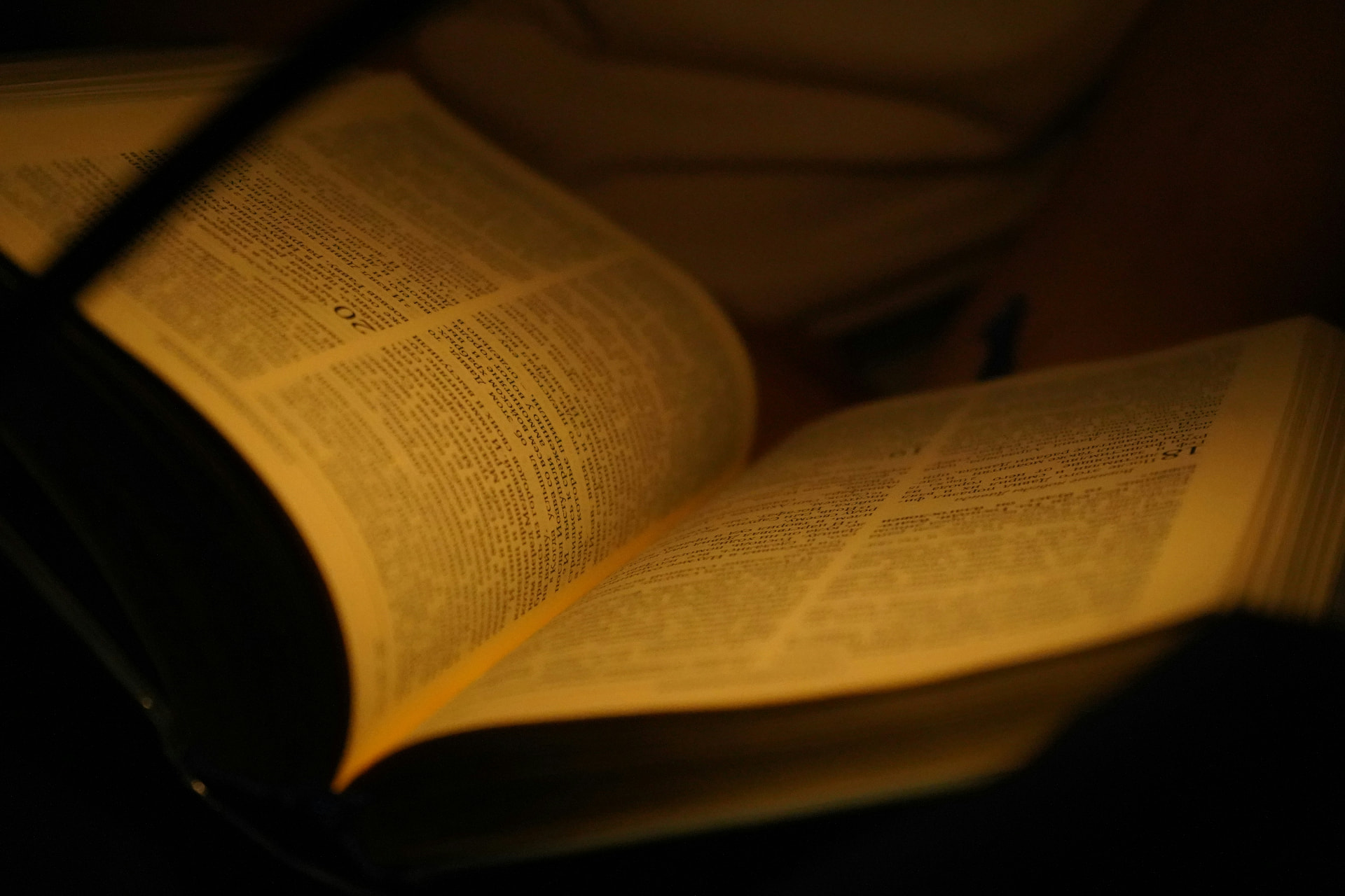 An open Bible lit by warm lamplight